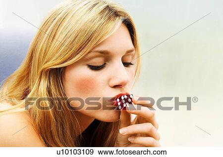 Stock Photo - Attractive Blonde Woman Kissing Dice. Fotosearch