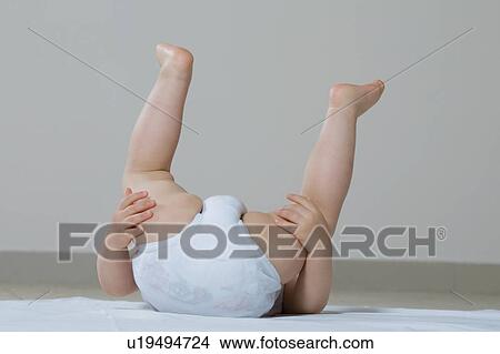 Baby girl playing on floor upside-down View Large Photo Image Picture - Baby girl playing on floor upside-down. Fotosearch