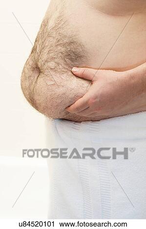 Stock Image - Barechested man with hands on belly. Fotosearch