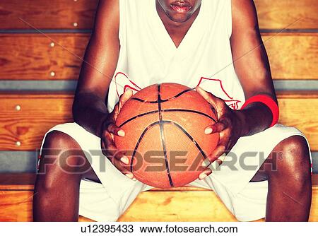 Stock Image - Basketball Player holding basketball. Fotosearch