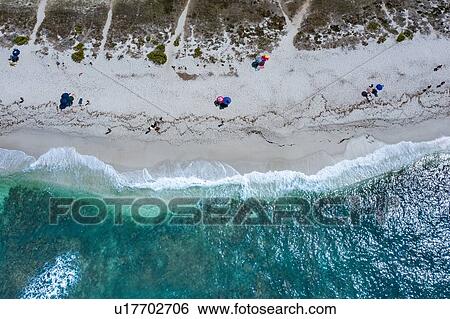 Stock Photograph - Beach umbrellas and holiday makers on beach, Oristano, Cagliari, Sardinia. Fotosearch