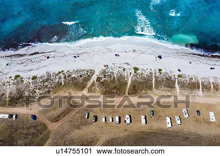 Stock Image - Beach umbrellas and vehicles parked beside beach, Villasimius, Cagliari, Sardinia. Fotosearch