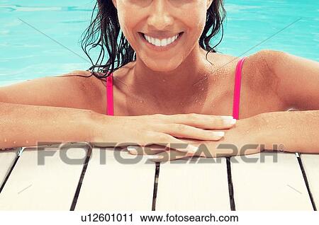 Stock Image - Beautiful brunette Woman in Swimming Pool. Fotosearch