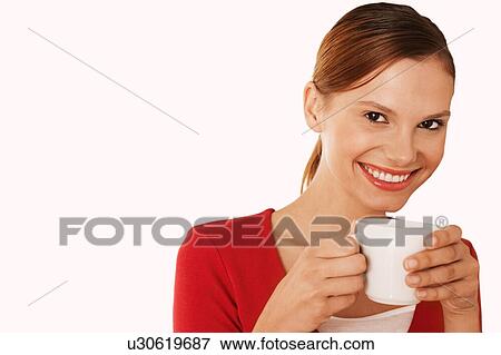 Beautiful woman drinking coffee against white background View Large Photo Image Stock Photo - Beautiful woman drinking coffee against white background. Fotosearch