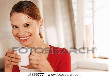 Stock Image - Beautiful woman drinking coffee at home. Fotosearch