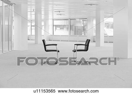 Stock Photography - Black and white photo of Two chairs in an empty office. Fotosearch