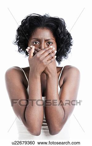 Stock Image - Black female with hands over her mouth. Fotosearch