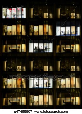 Stock Photo - Blurred photo of office building at night time. Fotosearch