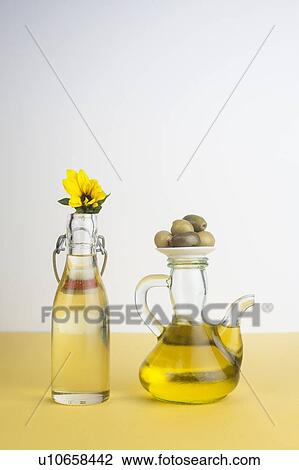 Stock Image - Bottle of sunflower oil and jug of olive oil. Fotosearch