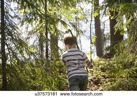 Stock Image - Boy exploring forest, Finland. Fotosearch