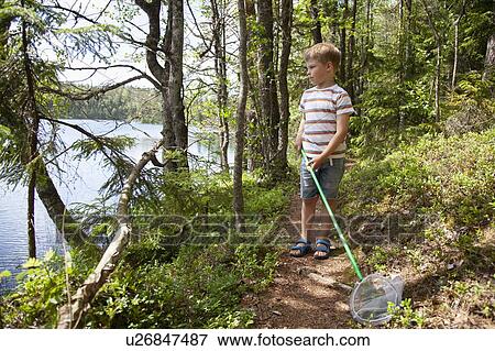 Stock Photo - Boy exploring forest, Finland. Fotosearch