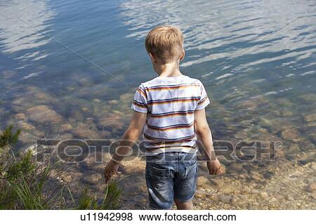 Stock Photo - Boy playing near lake. Fotosearch