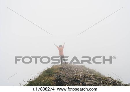 Boy raising arms in thick fog on hilltop View Large Photo Image Picture - Boy raising arms in thick fog on hilltop. Fotosearch