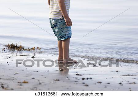 Boy standing on beach View Large Photo Image Stock Image - Boy standing on beach. Fotosearch