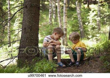 Stock Image - Brothers exploring forest, Finland. Fotosearch
