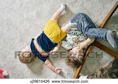 Brothers playing on carpet at home View Large Photo Image Stock Photograph - Brothers playing on carpet at home. Fotosearch