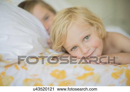 Stock Image - Brothers resting in bed. Fotosearch