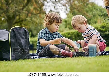 Stock Photography - Brothers sharing food in park. Fotosearch