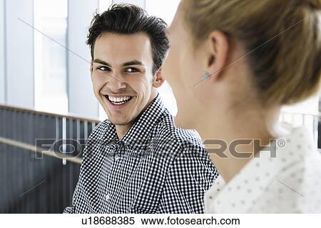 Stock Photography - Businessman and businesswoman talking in office. Fotosearch
