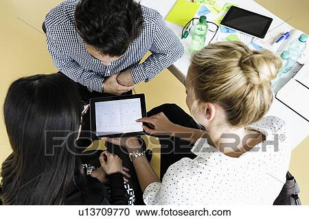 Businessman and businesswomen using digital tablet at meeting in office View Large Photo Image Stock Image - Businessman and businesswomen using digital tablet at meeting in office. Fotosearch