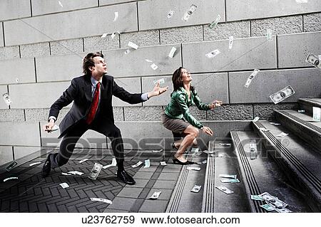 Businessman and woman catching falling money on steps View Large Photo Image Stock Photo - Businessman and woman catching falling money on steps. Fotosearch