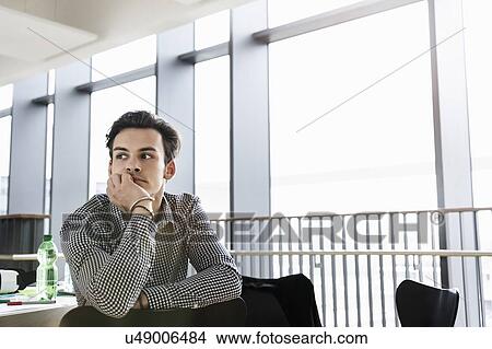 Businessman daydreaming in office View Large Photo Image Picture - Businessman daydreaming in office. Fotosearch