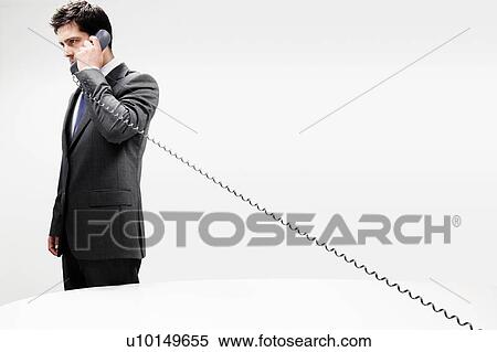 Stock Photography - Businessman in a suit on Cord Telephone. Fotosearch