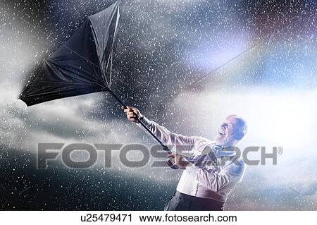 Businessman losing control of inside out umbrella View Large Photo Image Stock Image - Businessman losing control of inside out umbrella. Fotosearch