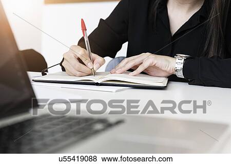 Businesswoman writing notes in office View Large Photo Image Stock Photo - Businesswoman writing notes in office. Fotosearch