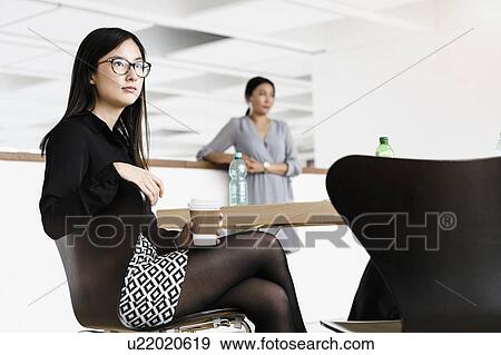 Businesswomen taking coffee break in office View Large Photo Image Stock Photo - Businesswomen taking coffee break in office. Fotosearch