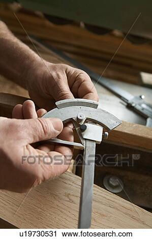 Stock Image - Carpenter Adjusting Calipers. Fotosearch
