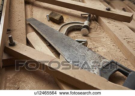 Picture - Carpenter's Saw and Clamp Among Wood Shavings. Fotosearch