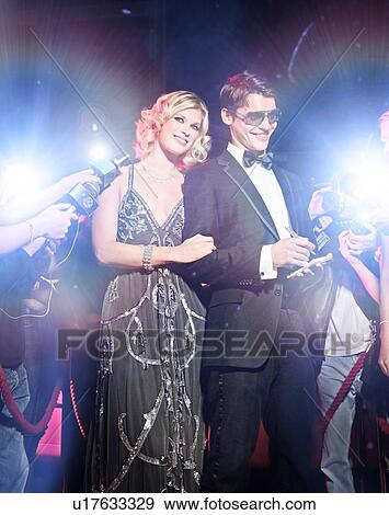Stock Photo - Celebrity couple arriving a premiere with paparazzi cameras and flashes. Fotosearch