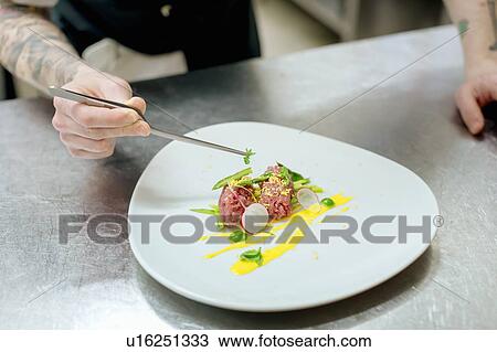 Chef preparing raw meat dish in kitchen View Large Photo Image Stock Image - Chef preparing raw meat dish in kitchen. Fotosearch