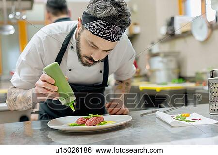Chef preparing raw meat dish in kitchen View Large Photo Image Stock Photograph - Chef preparing raw meat dish in kitchen. Fotosearch