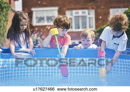 Children filling up water gun by pool View Large Photo Image Stock Photograph - Children filling up water gun by pool. Fotosearch