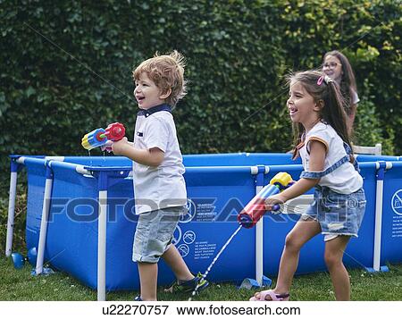 Children playing with water gun by pool View Large Photo Image Stock Photo - Children playing with water gun by pool. Fotosearch