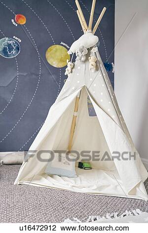 Stock Image - Child's teepee, mural of solar system on wall. Fotosearch