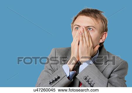 Close-up of a shocked businessman with hands covering mouth View Large Photo Image Stock Photography - Close-up of a shocked businessman with hands covering mouth. Fotosearch