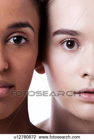Stock Image - Close up of black and white female faces together. Fotosearch