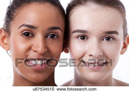 Stock Image - Close up of black and white female faces together. Fotosearch