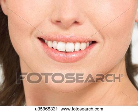 Stock Image - Close up of female white teeth smiling. Fotosearch