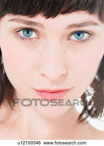 Stock Photograph - Close up of Young atrractive Brunette Woman with blue eyes. Fotosearch