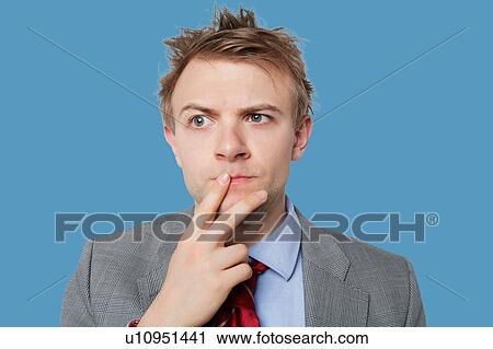 Stock Image - Close-up of young businessman thinking hard. Fotosearch
