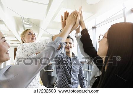 Colleagues giving high five in office View Large Photo Image Stock Image - Colleagues giving high five in office. Fotosearch