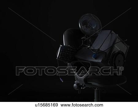 Stock Photo - Computer equipment and fan on office chair. Fotosearch