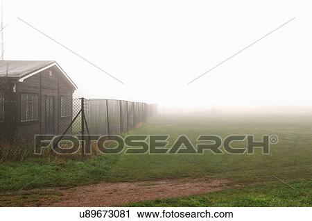 Cottage behind chainlink fence on foggy day View Large Photo Image Stock Image - Cottage behind chainlink fence on foggy day. Fotosearch