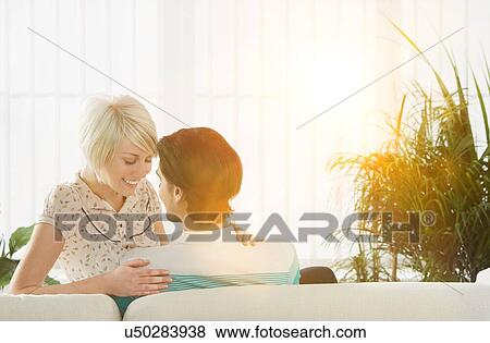 Couple embracing sitting on sofa rear view View Large Photo Image Stock Photo - Couple embracing sitting on sofa rear view. Fotosearch