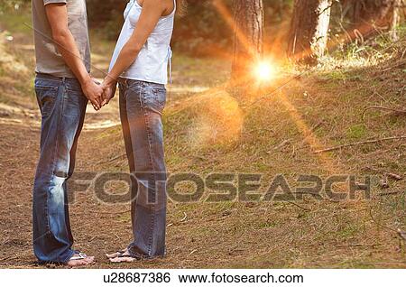 Stock Photograph - Couple in Forest Holding Hands. Fotosearch