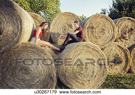 Couple sitting on bale of hay, Wilhelminenberg, Vienna, Austria View Large Photo Image Stock Photo - Couple sitting on bale of hay, Wilhelminenberg, Vienna, Austria. Fotosearch